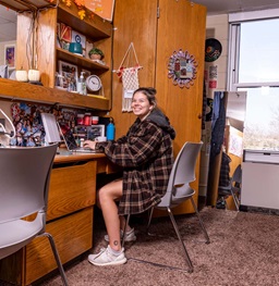 Student Sitting at Desk Inside Dorm Room