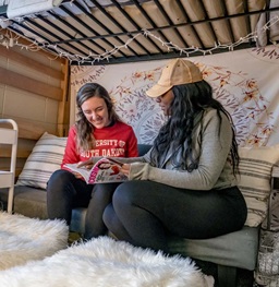 Two Females Reading a Magazine Inside Dorm Room