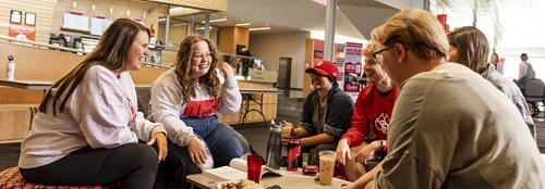 Students talking and having fun at a coffee table in the student center