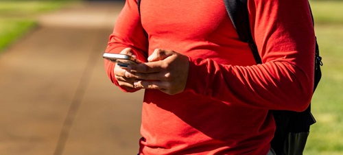 Student in Red Shirt Holding Cell Phone