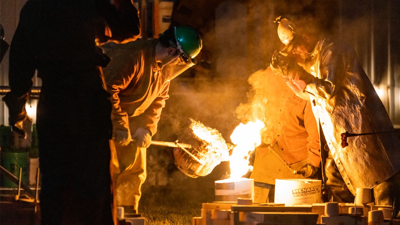 Three cast iron artists working at an iron pour Three cast iron artists working at an iron pour