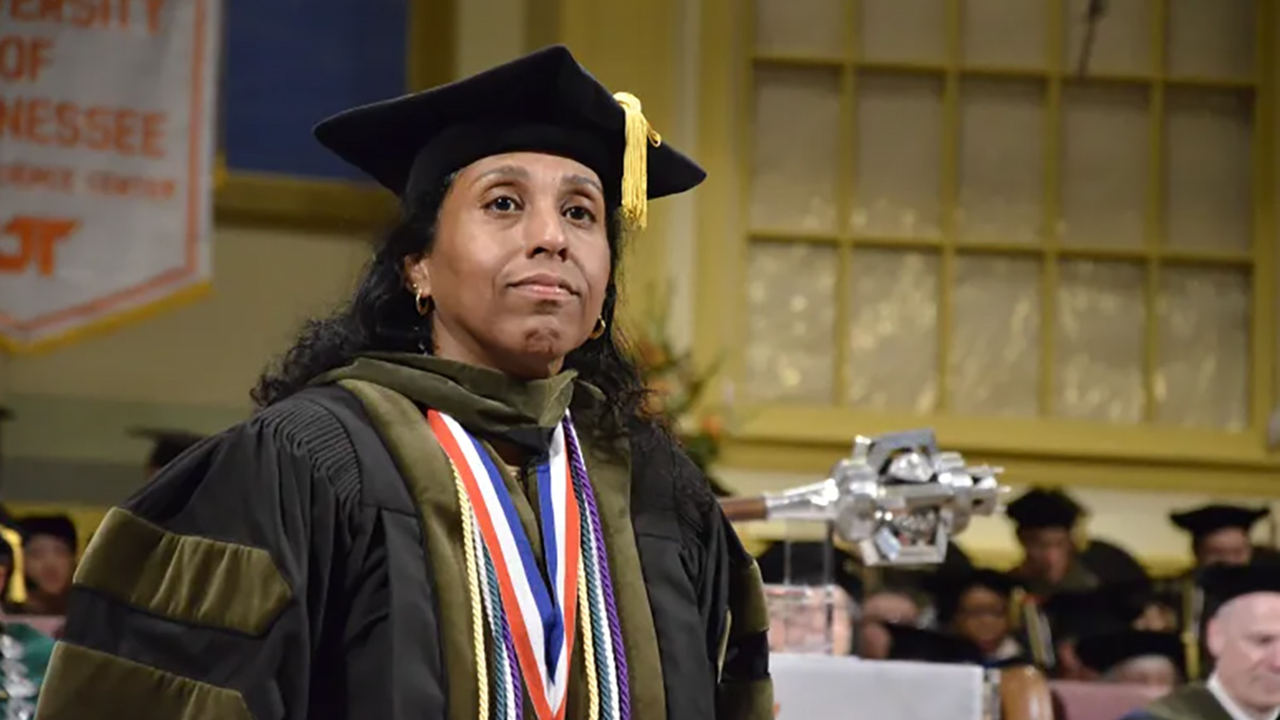 A photo of Marie Chisholm-Burns in her graduation gown, cap and cords.