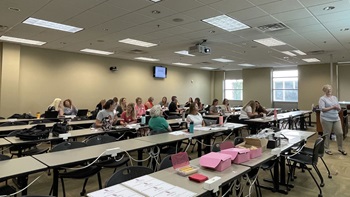 A group of nurses sit in a conference room at a training