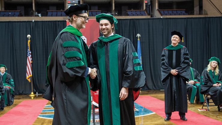 Photograph of Brooklyn DeVries shaking hands with his father, Dr. Brian DeVries, faculty at USD Sanford School of Medicine.