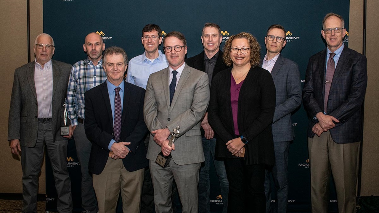 Photograph of Forest Brady, John Palmer, Bruce Eaton, Harold Fromm, Stu Fromm, Chris Fromm, Heather Brewer, Jason Knudson and Daniel Petereit.