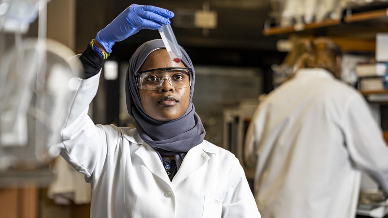 Trac hero image Student studying a tube in a lab