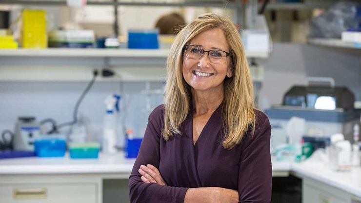 A portrait of Dr. Michelle Baack standing in a medical lab.