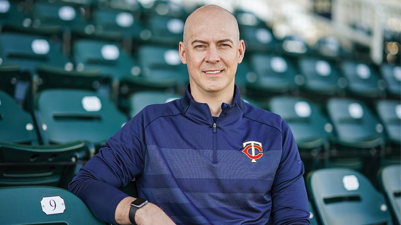A photo of Corey Wolf sitting in a row of stadium chairs.