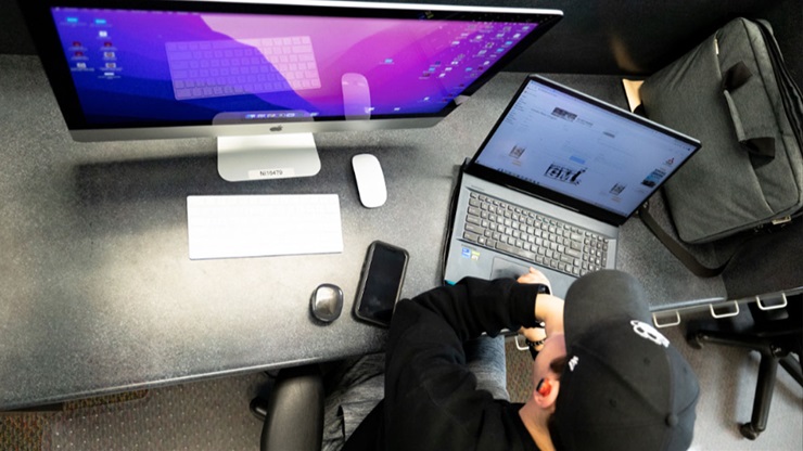 media and journalism student sitting at computer desk working