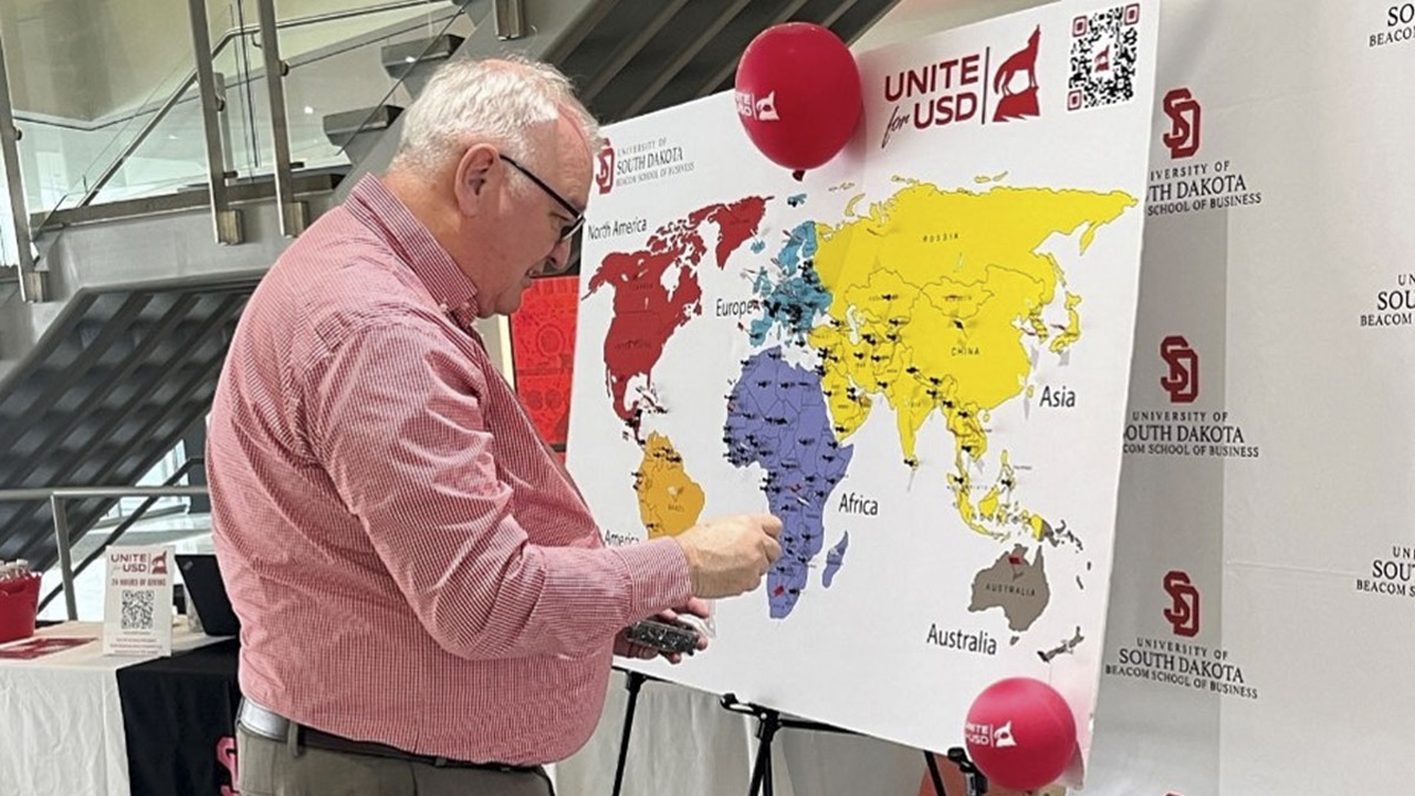 USD Beacom School of Business Interim Dean Mark Yockey places a pin on a country representing $5 gifted to the business school during Unite for USD USD Beacom School of Business Interim Dean Mark Yockey places a pin on a country representing $5 gifted to the business school during Unite for USD
