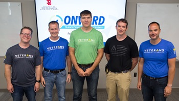 5 Onward students standing in front of whiteboard in a row