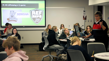 College students sit in a classroom while someone from the SDHSAA educates them on K-12 sports officiating.