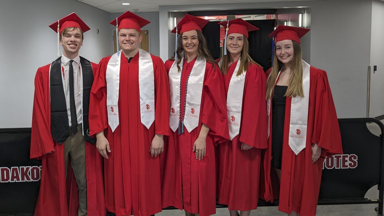 USD Teacher Pathway Program students stand together in their caps and gowns at commencement USD Teacher Pathway Program students stand together in their caps and gowns at commencement