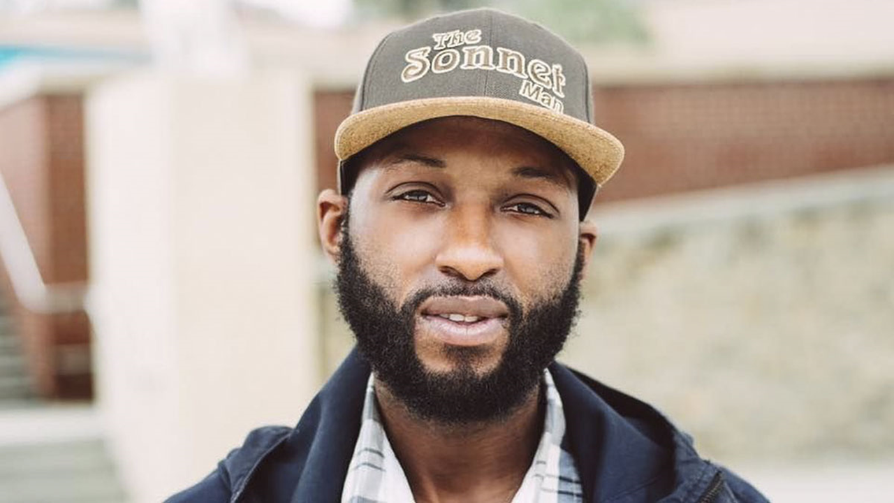 Devon Glover standing in front of tan wall