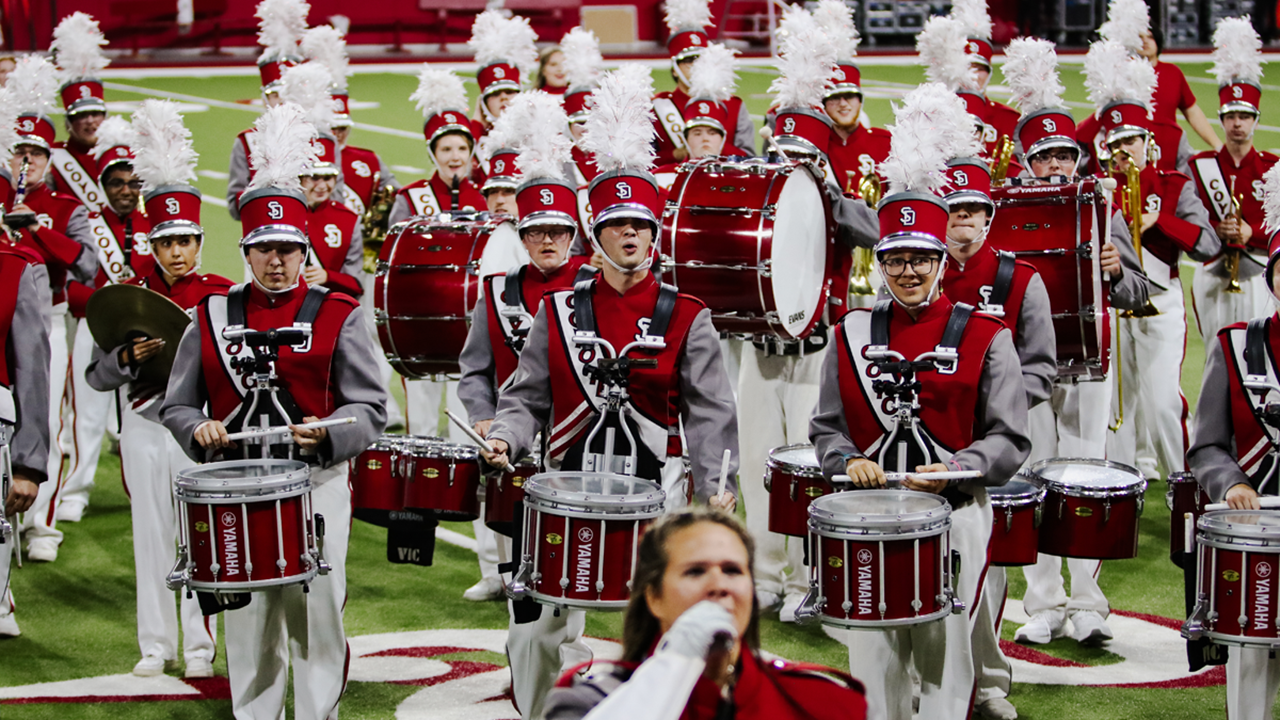 USD's marching band lines up and performs on the football field.