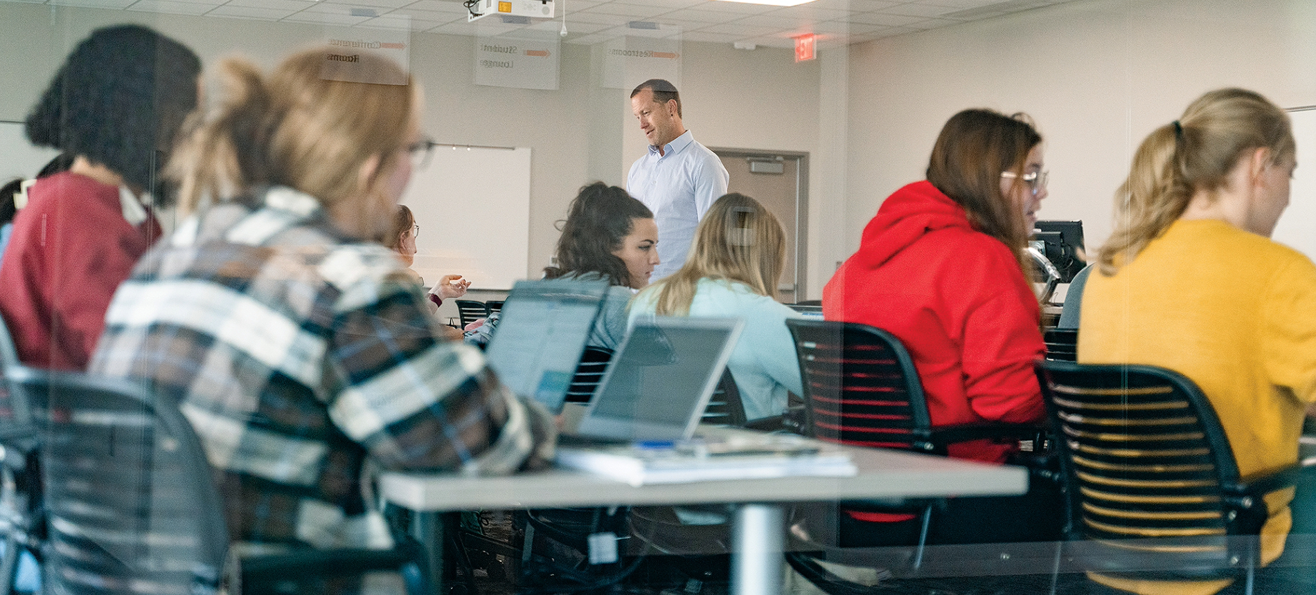 Health sciences students sitting in class with their laptops and taking notes.