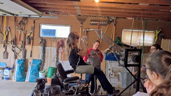 A USD OT student tries out one of Harlan Temple's lifts in his garage.