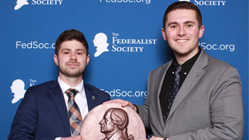 Two USD law students pose with the award for Most Improved Chapter presented by the Federalist Society.