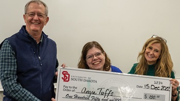 Angie Tuffs with Dr. Tim Ridgway, standing together with the USD Employee of the Month award of a $150 check.