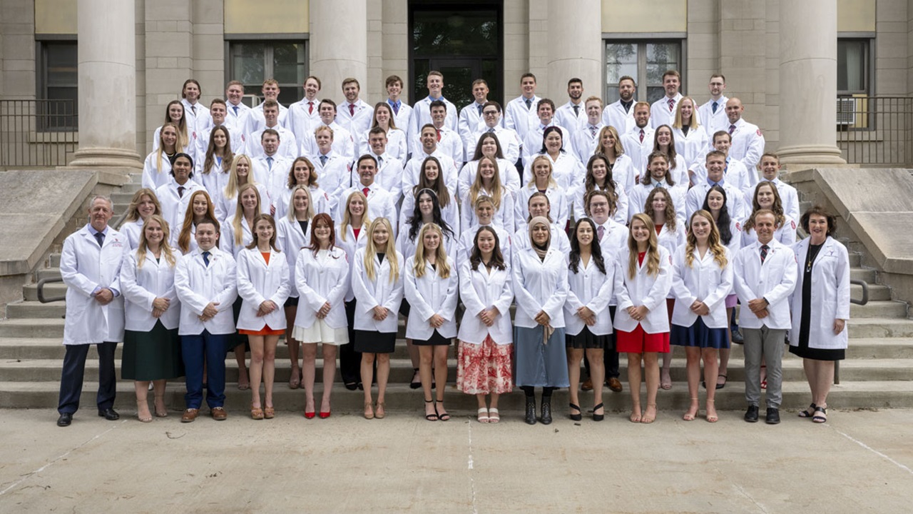 71 first-year medical students stand together in their white coats 71 first-year medical students stand together in their white coats