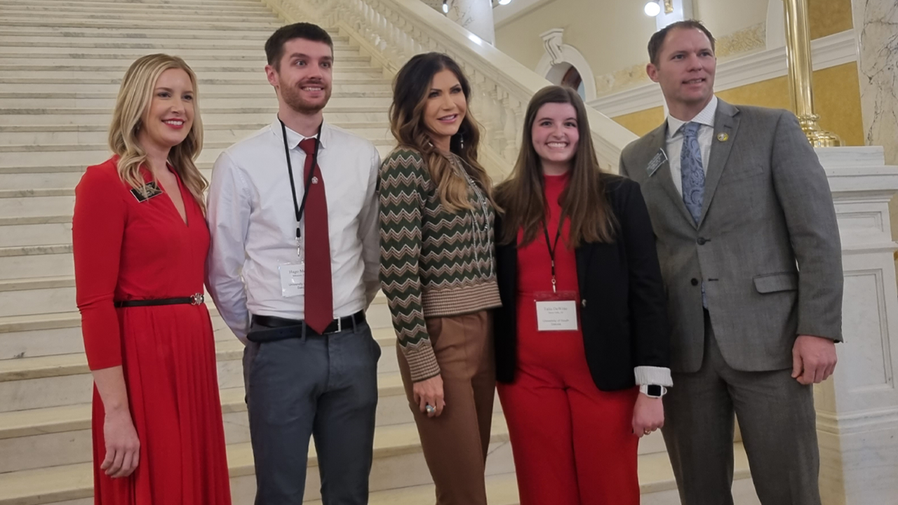 Two students and two legislators stand together with Governor Kristi Noem for a photo at the South Dakota State Capitol.