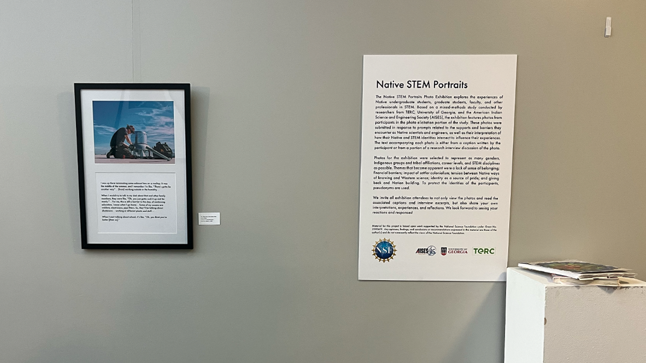 A blank wall with a framed photo and an art exhibition explanation on a white poster.
