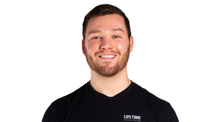 A headshot of Nick Fey. He is wearing a black t-shirt and standing against a white background.