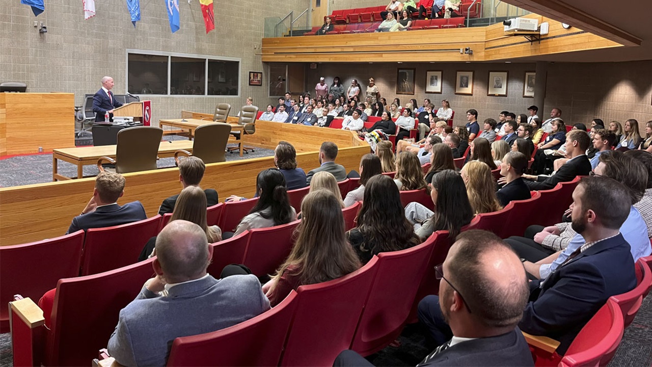 The Knudson School of Law Class of 2027 sits in the USD courtroom, listening to Dean Neil Fulton provide a welcome speech. The Knudson School of Law Class of 2027 sits in the USD courtroom, listening to Dean Neil Fulton provide a welcome speech.