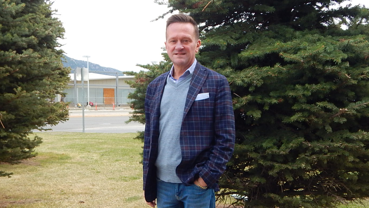 Ty Inglis stands in front of a tree with one hand in his pocket.