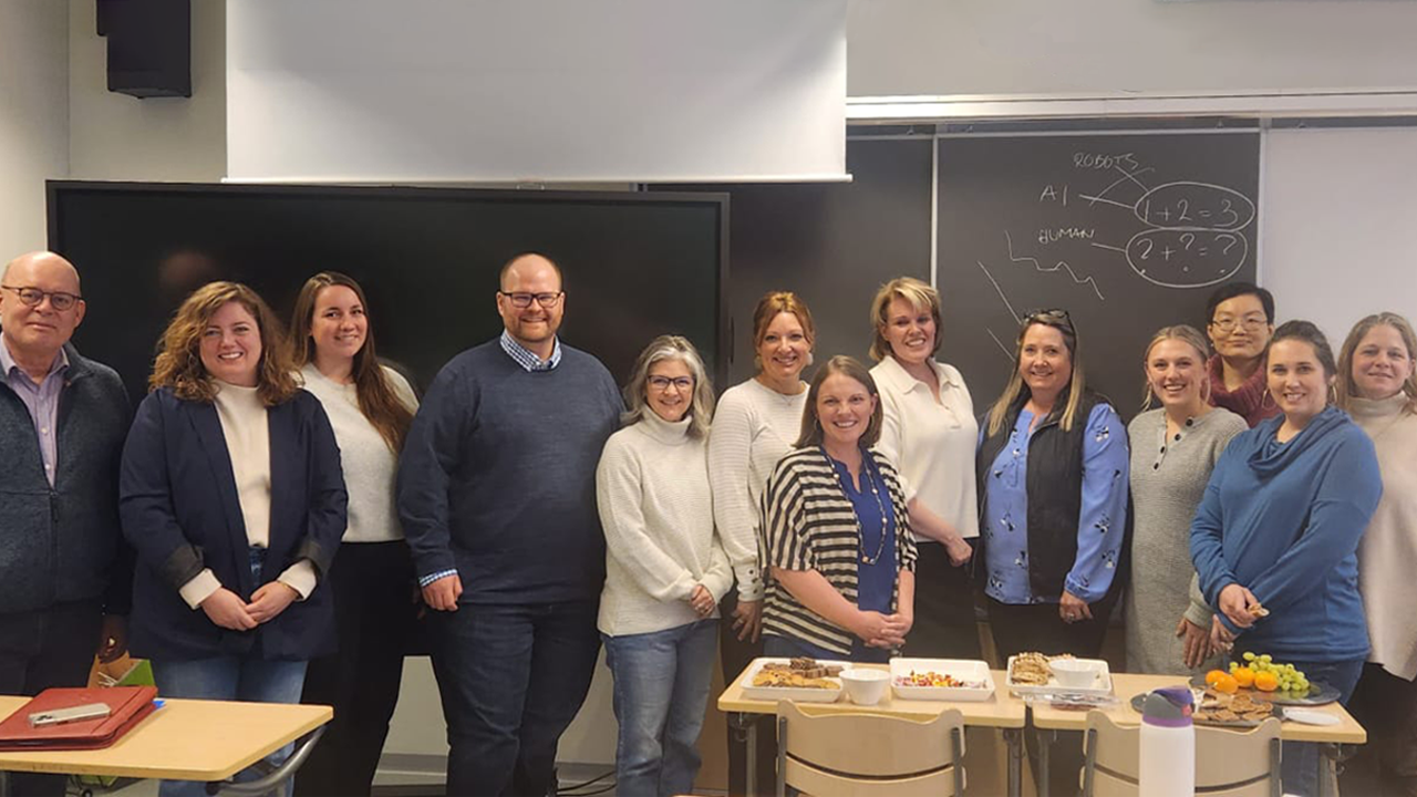 USD School of Education and Vermillion Public Schools faculty stand together for a photo in a classroom.