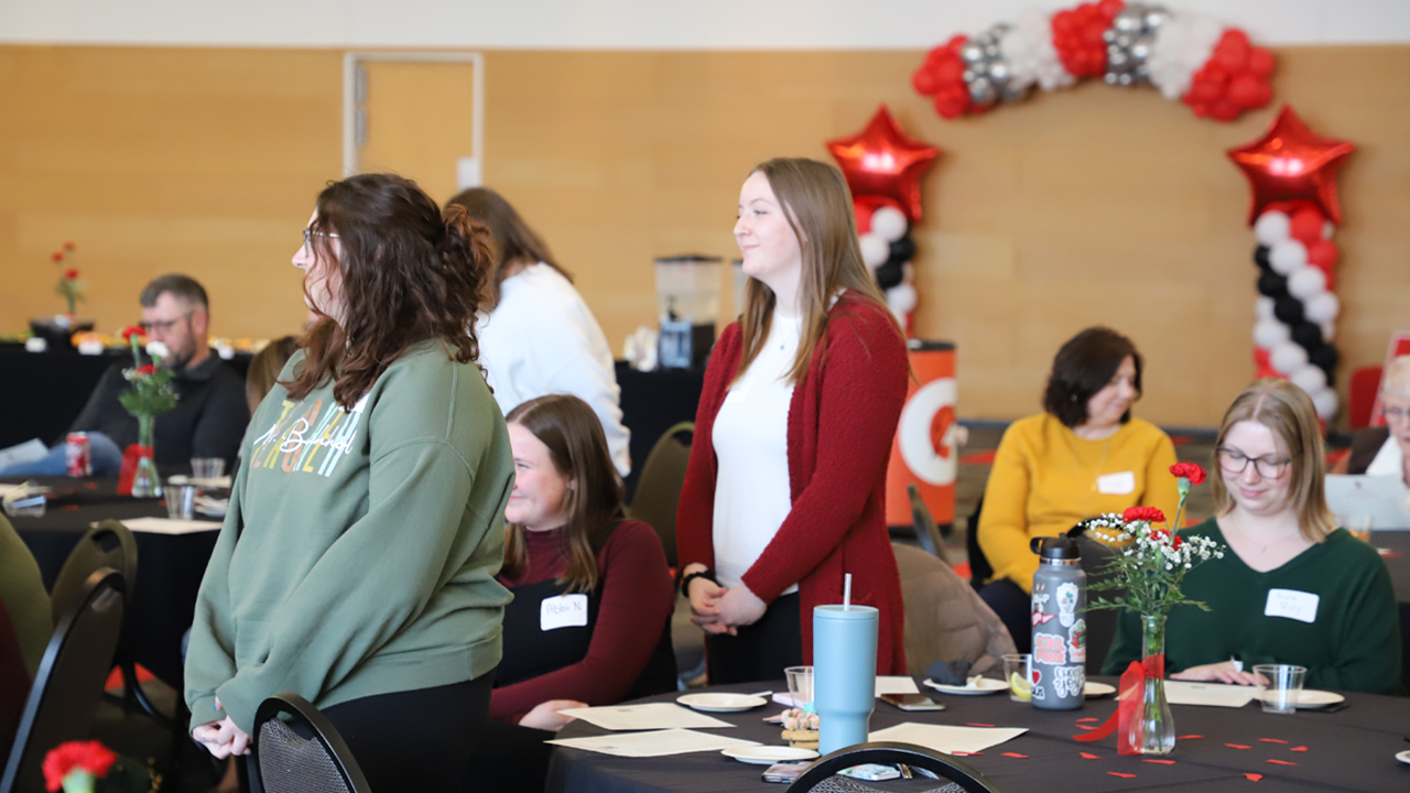 Two students stand to be recognized at the School of Education awards banquet.