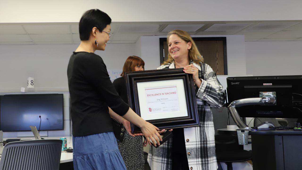Amy Schweinle presents an award to Jing Williams.