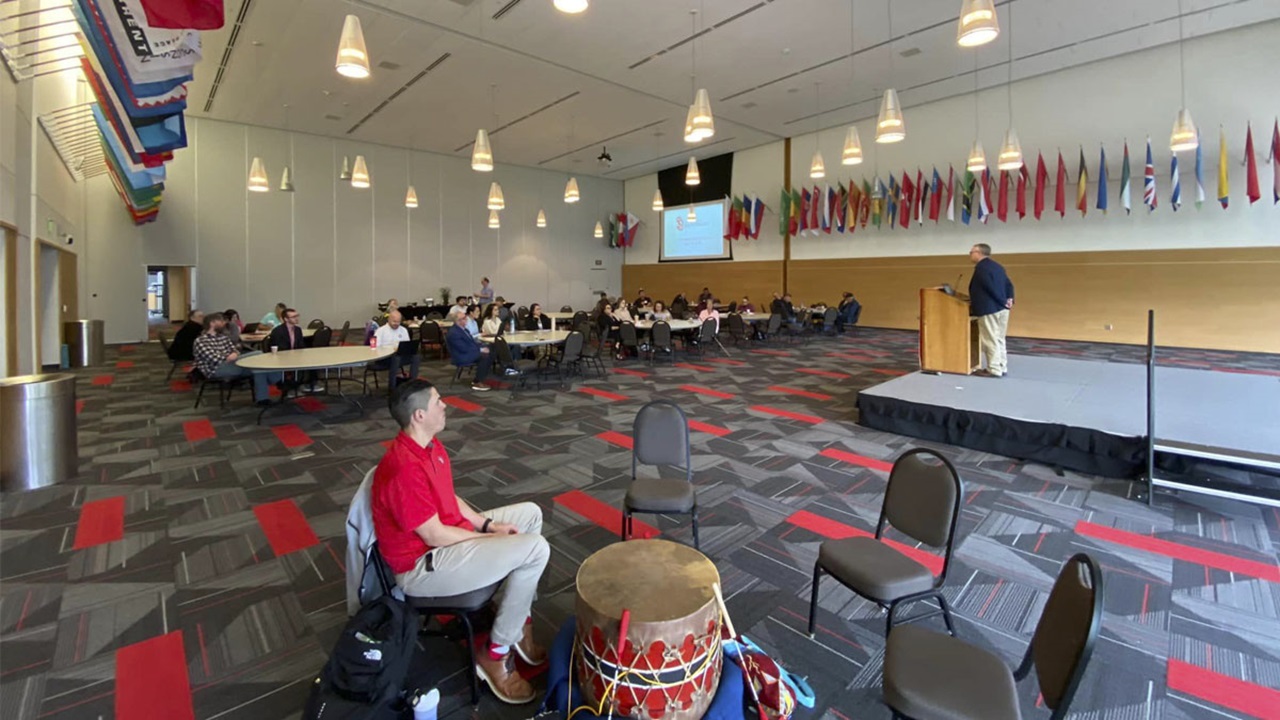 A group of people in a crowd watch a speaker at the podium during the 2023 USD-Tribal Historic Preservation Office Gathering. A group of people in a crowd watch a speaker at the podium during the 2023 USD-Tribal Historic Preservation Office Gathering.
