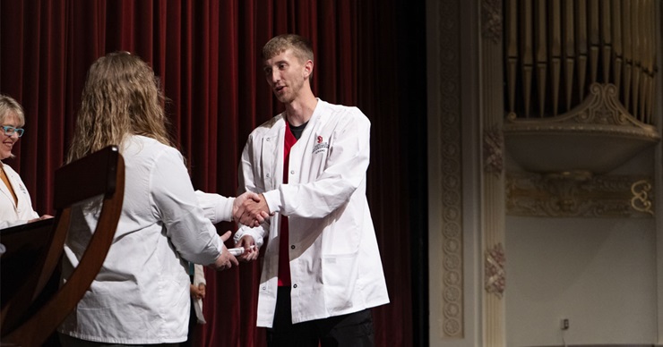 Dalten Bremer receives a certificate from USD Nursing faculty. Dalten Bremer receives a certificate from USD Nursing faculty.