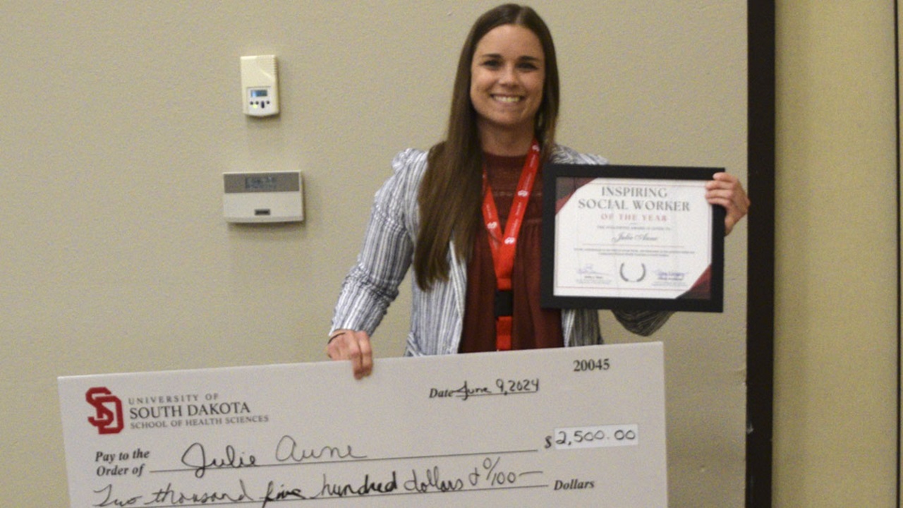 Julie Aune holds her certificate and a check made out for $2,500, her award for receiving "Inspiring Social Worker of the Year." Julie Aune holds her certificate and a check made out for $2,500, her award for receiving "Inspiring Social Worker of the Year."