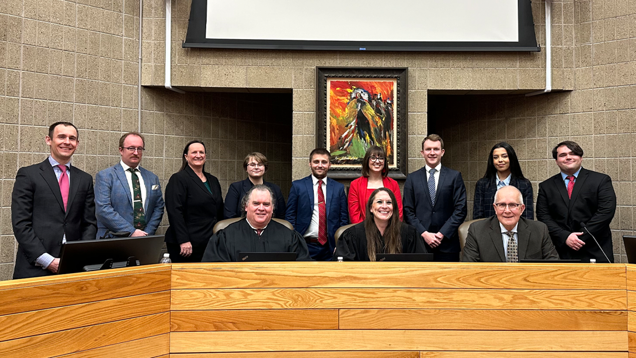 Students stand with federal bankruptcy judges in the USD law school courtroom.