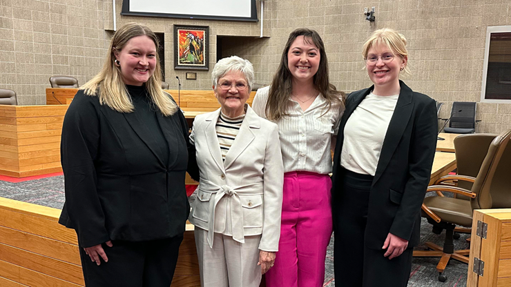 Isabelle Kremeier, Justice Judith Meierhenry, Hannah Dosch and Kate Anderson stand together for a photo in the law school courtroom.