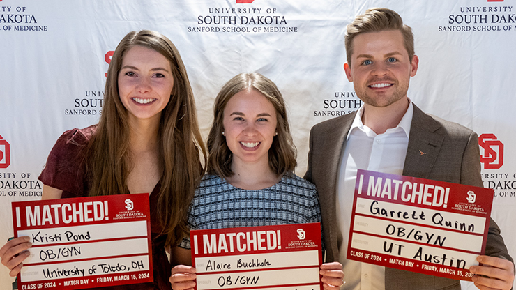 Three students smile and hold up signs that say "I Matched!" and lists their name, specialty and match location.