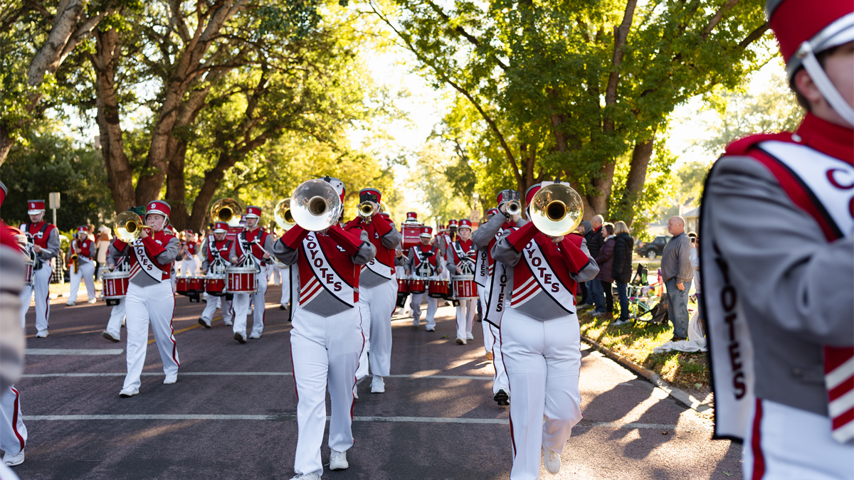 The SOUND of USD marches in the Dakota Days parade wearing red and white marching band attire.