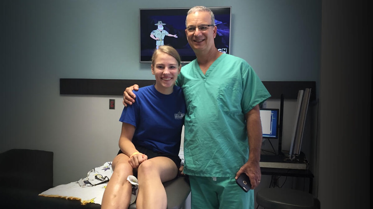 Haley Grudzinski sits on a patient's table, next to Dr. Dror Paley, a renowned Canadian-trained orthopedic surgeon specializing in limb lengthening and deformity correction procedures at the Paley Orthopedic & Spine Institute.