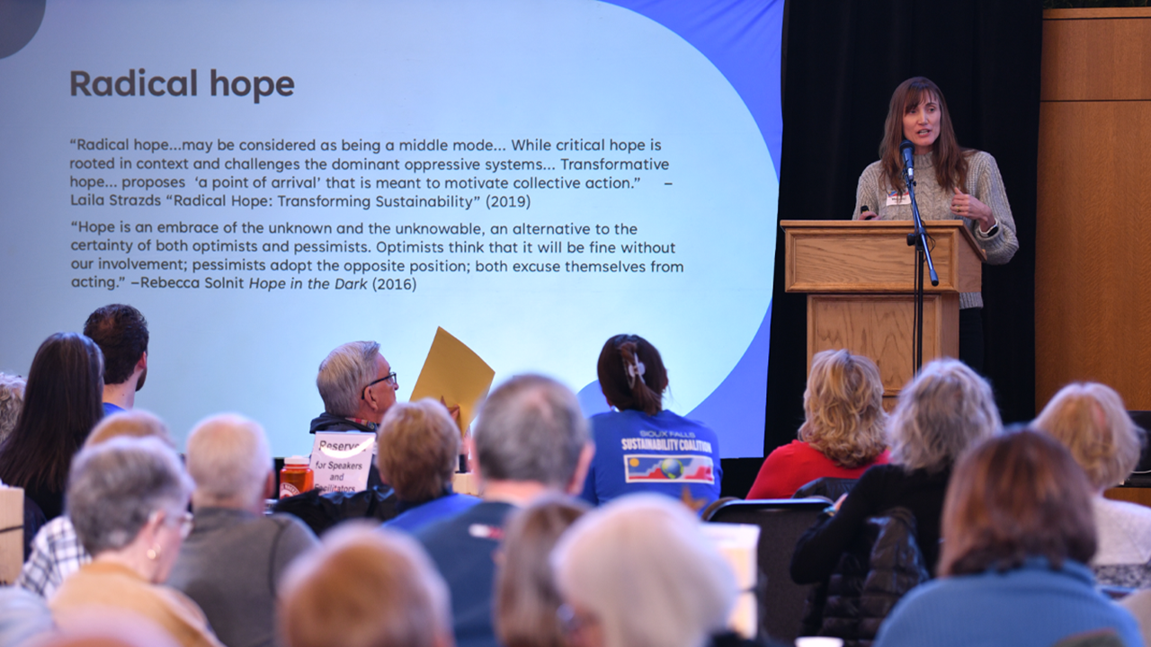 Meghann Jarchow, Ph.D., chair and professor in the Department of Sustainability & Environment at USD stands at a podium and gives a presentation.