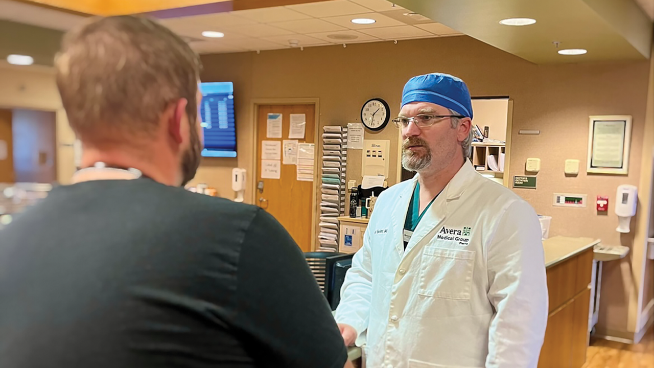 Dr. Brandt Becker ’08, speaks to a patient about their healthcare journey.