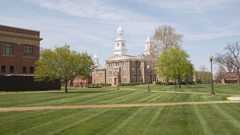 A view of Old Main in the spring. The grass is green and the sky is blue. A view of Old Main in the spring. The grass is green and the sky is blue.