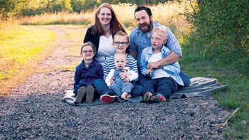 The Turner family sits on a gravel road, posing for family pictures.