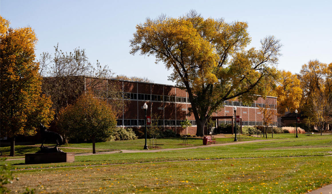 The Delzell Education Center sits on a sunny USD campus, surrounded by fall trees.