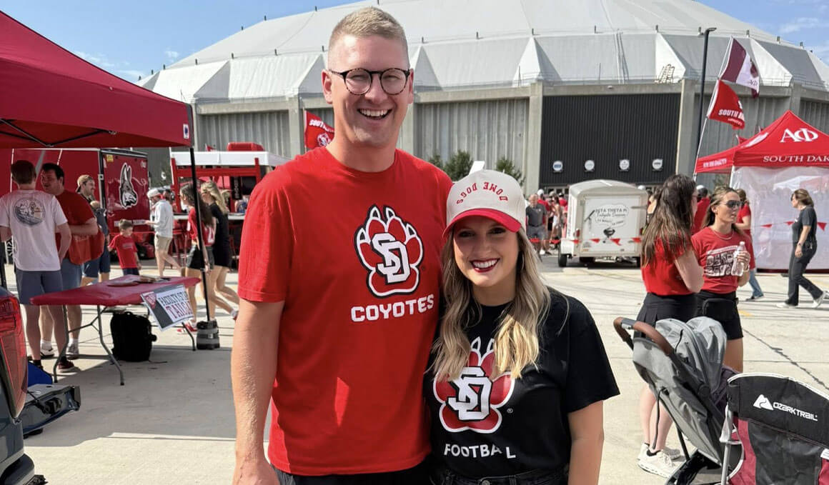 Kyle Schoenfelder stands with his wife, Ashlin, at a tailgate outside of the DakotaDome.