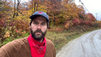 Man takes a selfie while on a walk in the fall. 