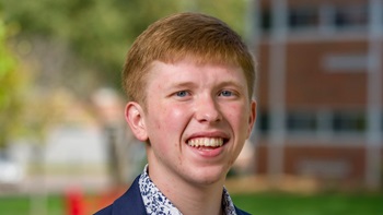 USD student Carter Linke smiles on campus.