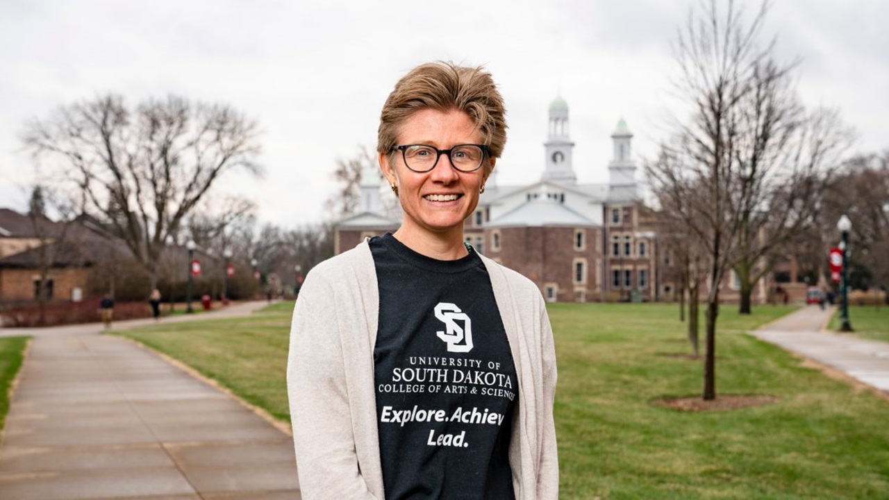 Prentiss Clark smiles in front of Old Main .
