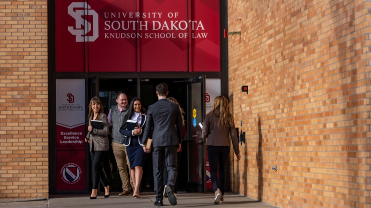 Students pass each other as they leave and enter the Knudson School of Law building.